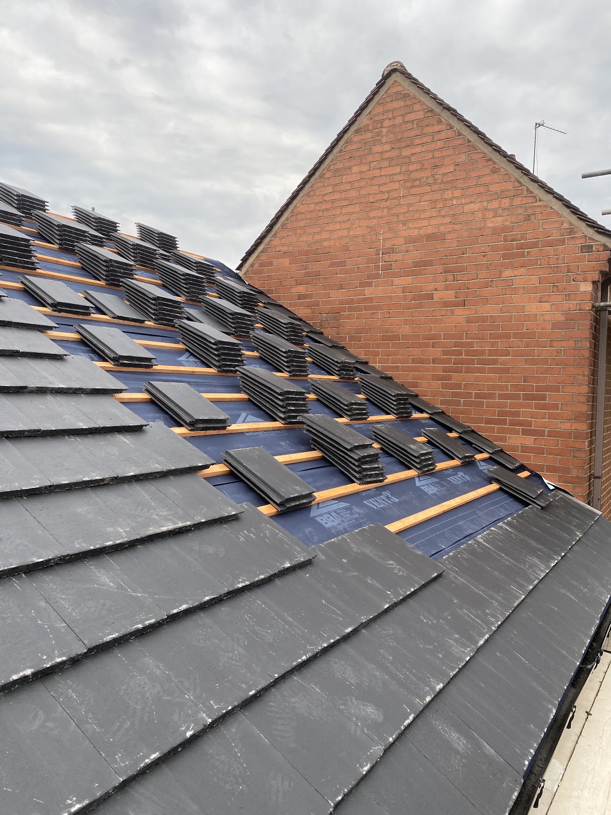 New plain tiles being fitted on fresh membrane