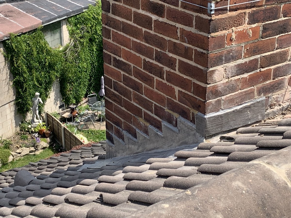 Fresh lead soakers around a chimney stack